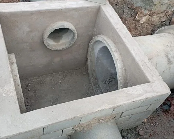 Poço de visita de concreto com as tubulações de entrada e saída posicionadas